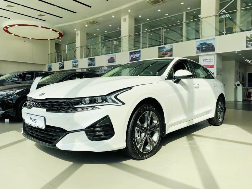 Белый Kia K5 в ташкентском автосалоне