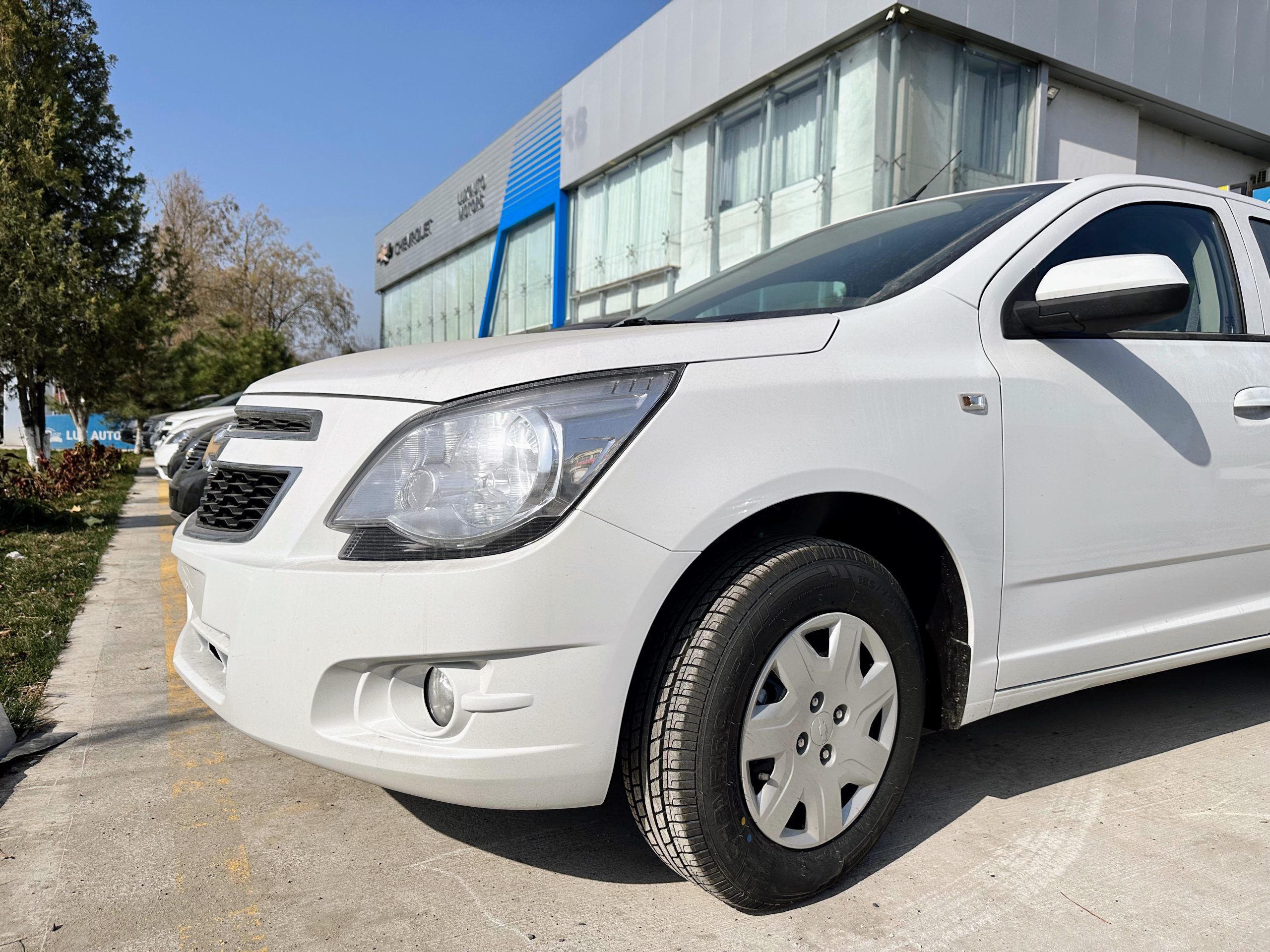 Дикий рынок: сколько стоят новые Cobalt и Gentra на машинном базаре? - 1 Chevrolet Cobalt Optima AT (без ABS) на стоянке автосалона в Ташкенте