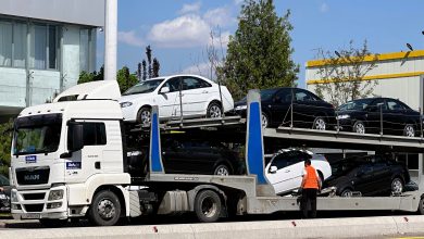Трейлер с автомобилями Chevrolet Lacetti разргужается у автосалона UzAuto Motors в Ташкенте