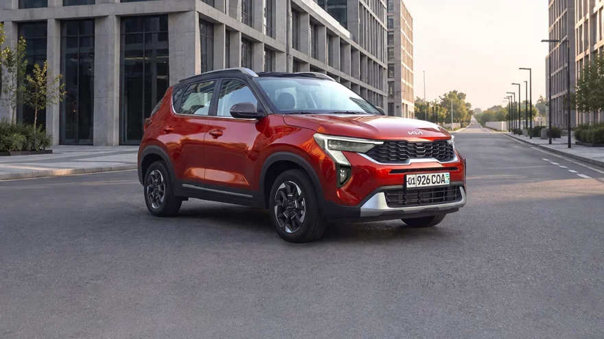 0% рассрочка и льготный автокредит на Kia Sonet - 2 Красный Kia Sonet Prime спереди сбоку на пустой улице между офисными зданиями